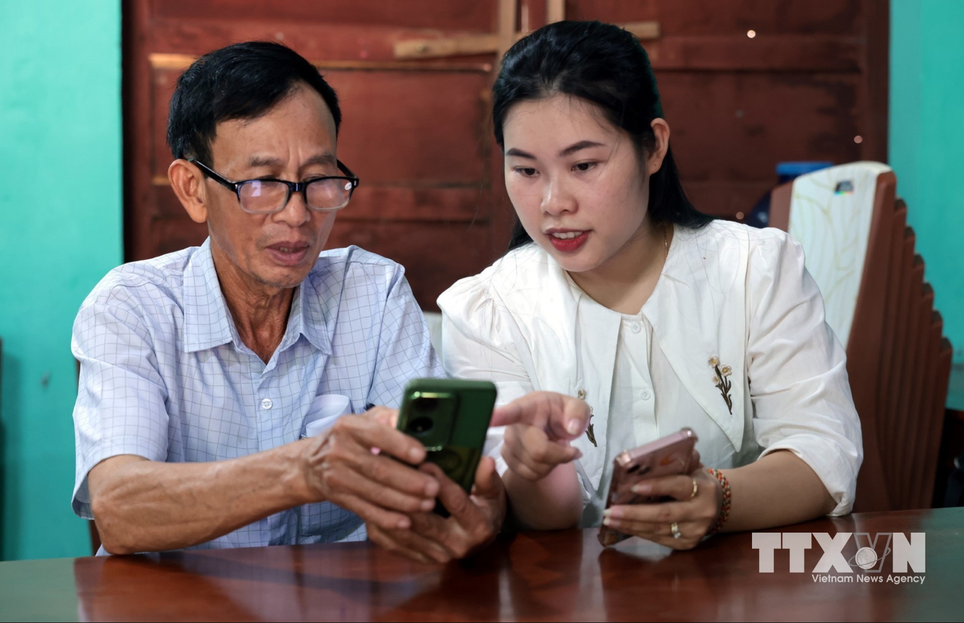 Cán bộ Trung tâm đổi mới sáng tạo và chuyển đổi số Quảng Trị hướng dẫn các “Tổ công nghệ số cộng đồng” xã trợ giúp người dân cài đặt, khai thác, sử dụng thông tin trên ứng dụng Quangtri- S và các ứng dụng khác. (Ảnh: Trần Việt/TTXVN)